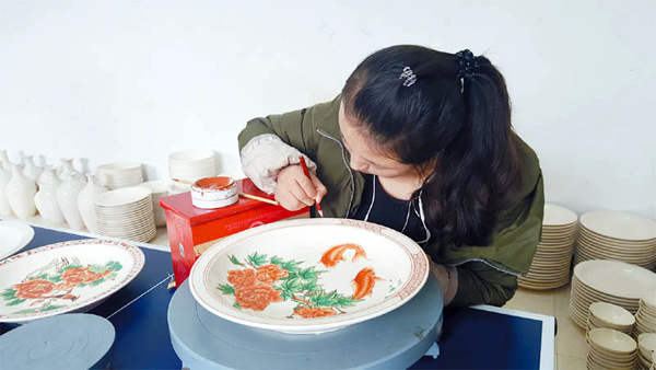 长治县八义窑红绿彩陶瓷文化有限公司的画师正在上色